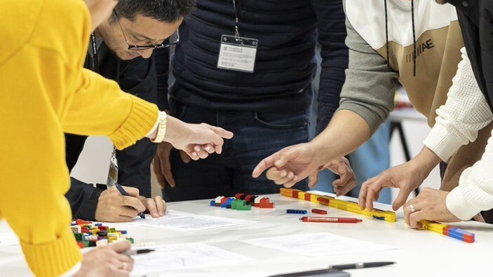 Executive Education participants working with Lego pieces during a workshop.