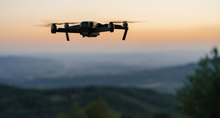 Drone flying over sustainability project landscape at dusk.