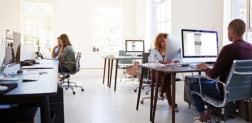 Shot of colleagues working on their computers in an open plan office