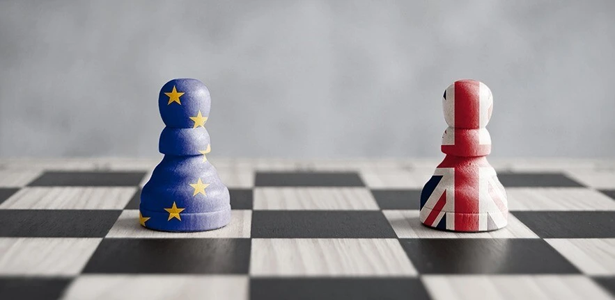Two pawns with UK and European flags on a chess board