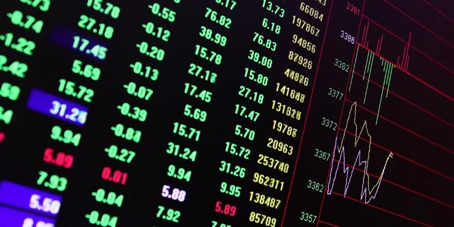 A black computer screen displaying colourful economy data and graphs.