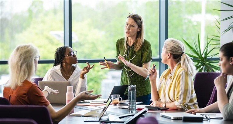 Corporate women speaking in the office.