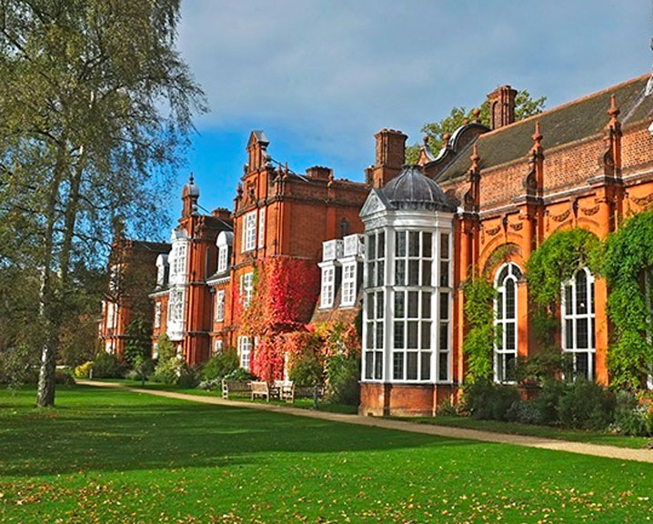 The red brick facade of Newnham College surrounded.