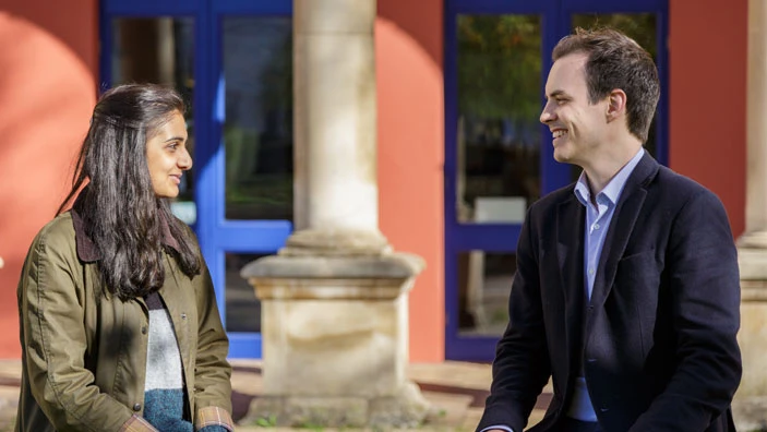 Two students engaged in conversation outside Cambridge Judge.