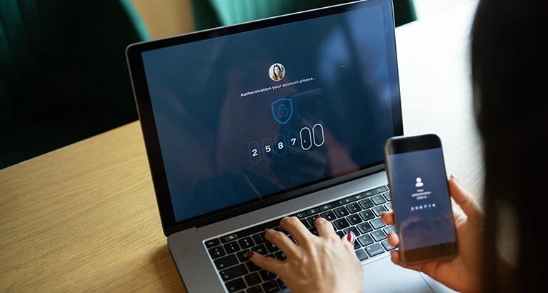 Woman using authentication on a financial account via a laptop.