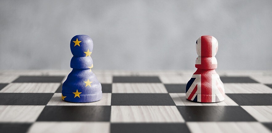 Two pawns with UK and European flags on a chess board
