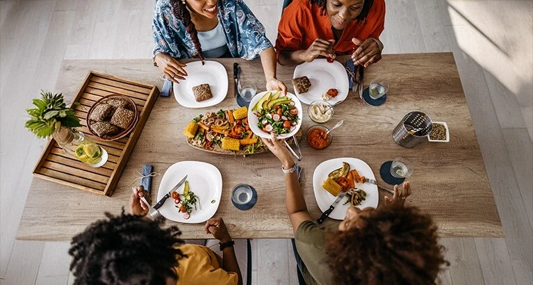 People gathered around a table of food.
