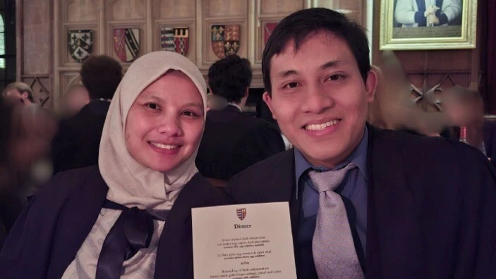 Bachrum Lubis attending a college dinner and holding the menu.