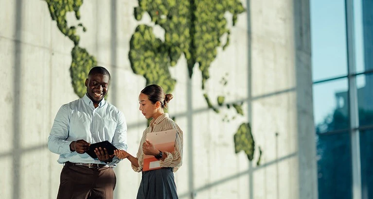 Colleagues in front of a large world map.