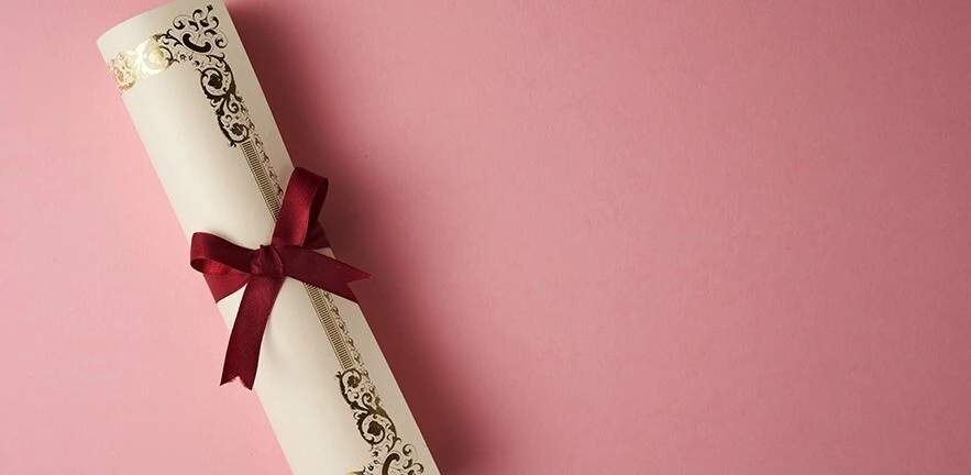A ribboned scroll on a pink background.