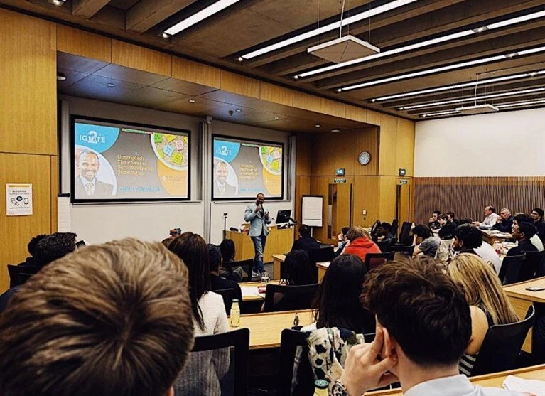 Executive MBA 2023 Student Gok Yesodharan presents to an audience of local young people, and fellow EMBA cohort members.