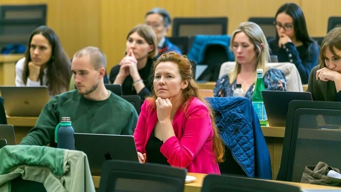 Students engaged in a classroom setting, focusing on a social innovation lecture.
