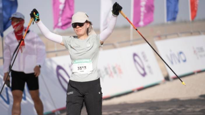 A Cambridge Judge Business School participant holding walking poles at the Will of Nature - Gobi to West 2025 event.