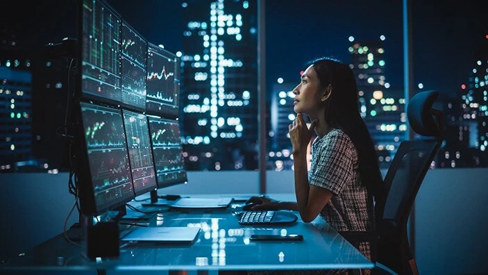 Woman looking at financial screens.