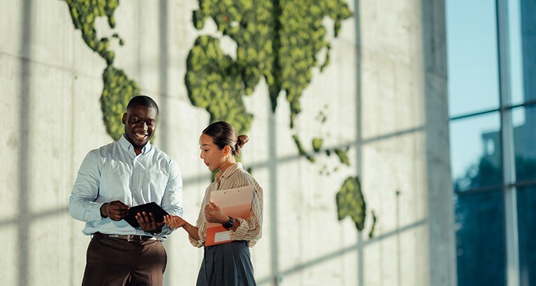 Colleagues in front of a large world map.