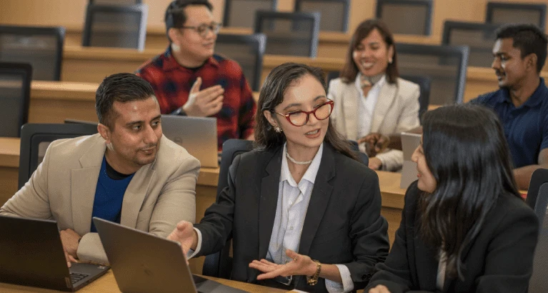 MFin students talking in the lecture theatre.