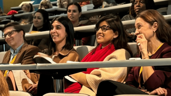A lecture theatre populated with attendees of the Wo+men's Leadership Conference.