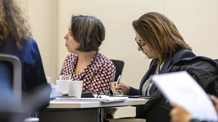 Women sitting and writing in a classroom.