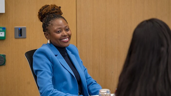 Woman in business suit smiling.