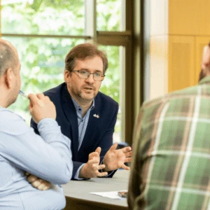 Professor David Stillwell talking to delegates around a table
