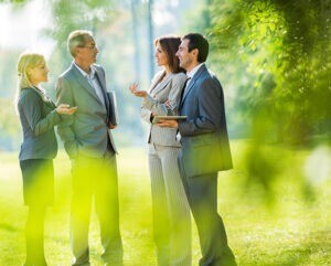 People in suits talking to each other outdoors.