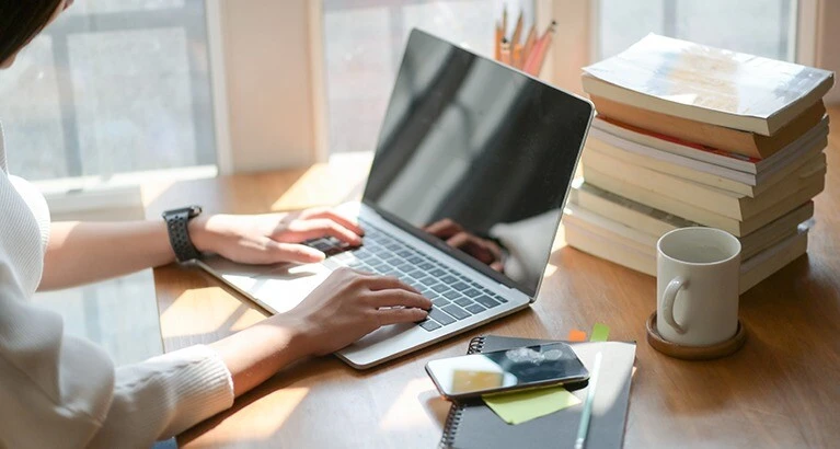 Businesswoman using laptop in office.