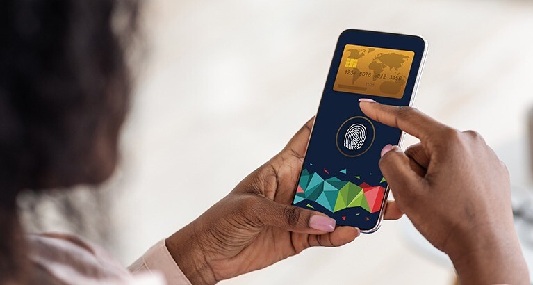 Woman making digital payment on her mobile device using biometric ID.