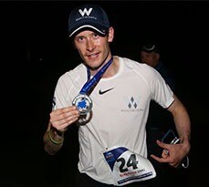Greg Nance holding a marathon medal.
