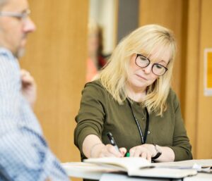 Participant writing during a peer discussion during leadership programme