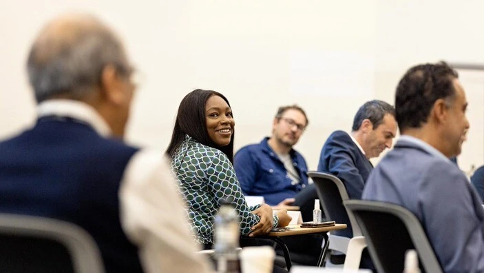 Participant smiling during a discussion in an Executive Education session.