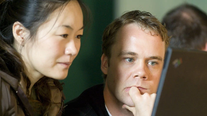 Two people collaborating over a laptop.
