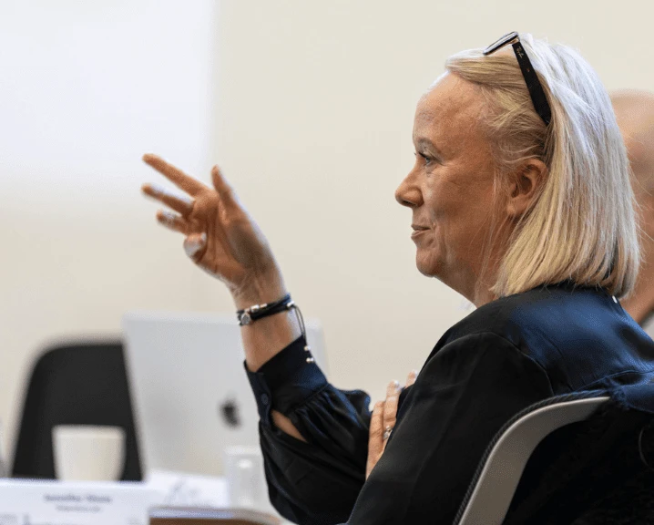 A participant gestures while listening during an leadership programme session.