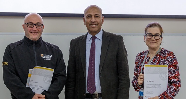 Gishan Dissanaike (centre) presents the awards to Khaled Soufani (left) and Feryal Erhun (right).