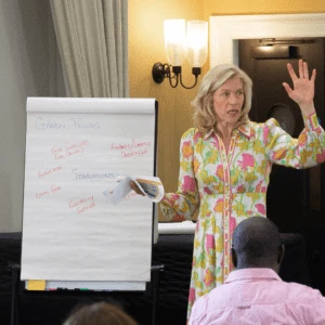 Professor Jennifer Howard presenting to class with whiteboard
