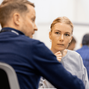 A woman in class listening to peers ideas