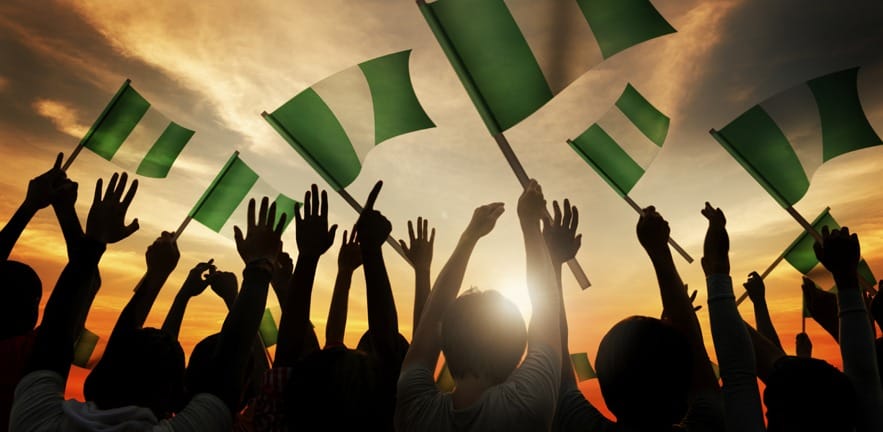 Silhouettes of People Holding Flag of Nigeria