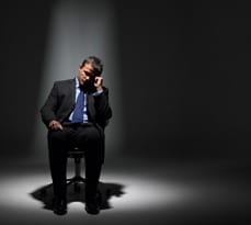 Businessman Sitting In Spotlight