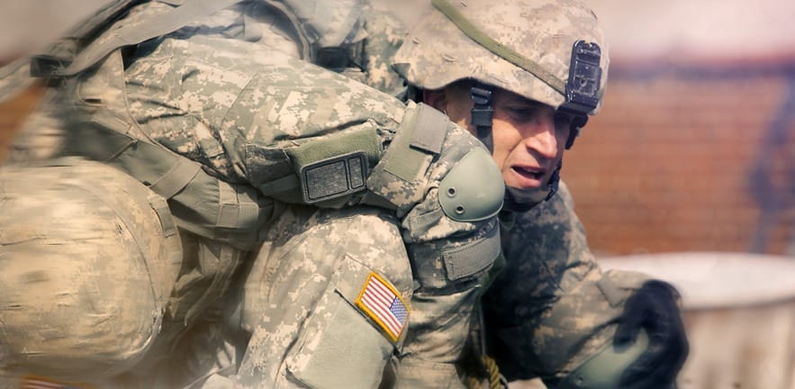 Soldier carrying another wounded soldier in the battle field. Acton photo of war-time action.