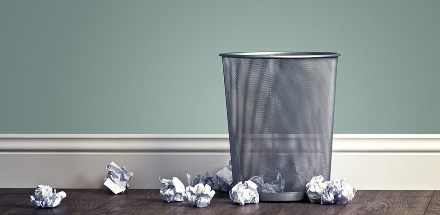 Waste paper basket with paper balls around it