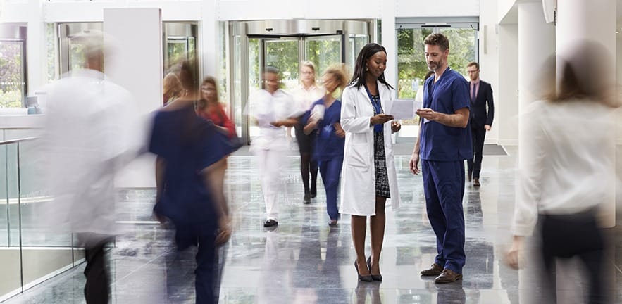 Staff In Busy Lobby Area Of Modern Hospital