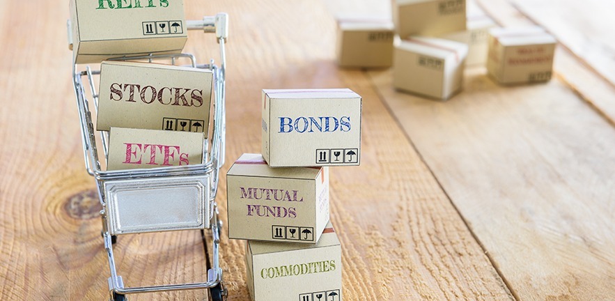 Cartons of financial investment products in a shopping cart i.e REITs, stocks, ETFs, bonds, mutual funds, commodities. A concept of portfolio management with risk diversification for optimal returns.