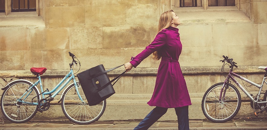 Woman walking through Cambridge with her postbox handbag 