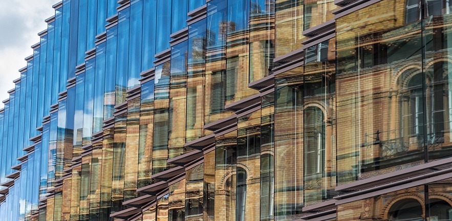 old building facade reflection in modern building glass facade - old building facade, new building exterior.