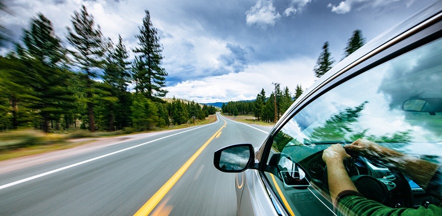 Car driving down a scenic road - sense of motion from blur of the image.