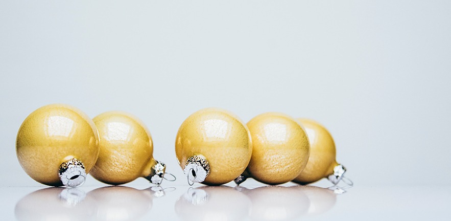 Gold baubles on a shiny surface.