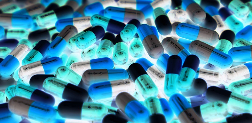 Pile of blue, green and white pills.