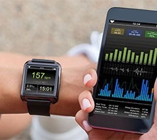 Female Runner Looking At Her Mobile And Smart Watch Heart Rate Monitor