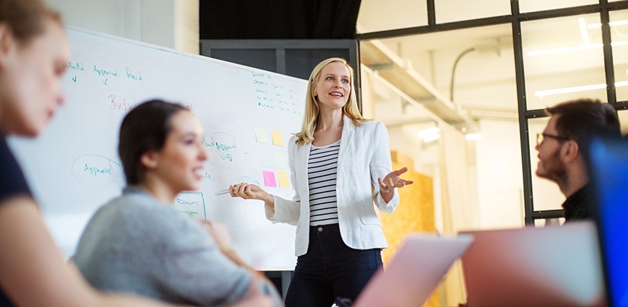 Young businesswoman giving presentation on future plans to her colleagues at office