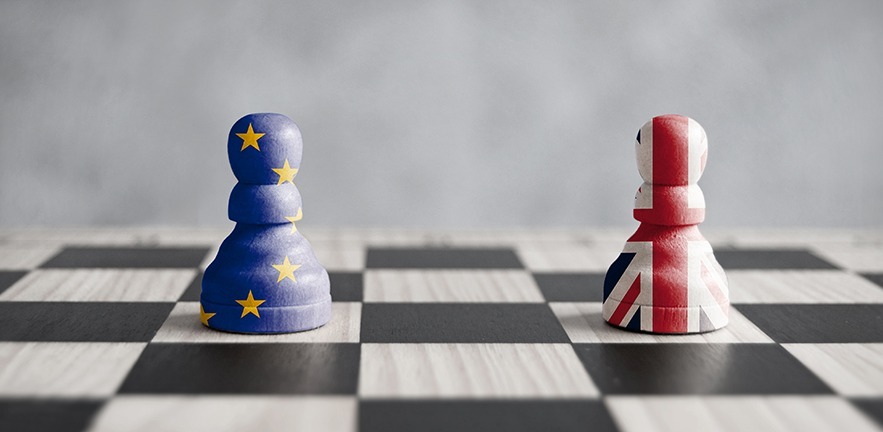 Two pawns with UK and European flags on a chess board