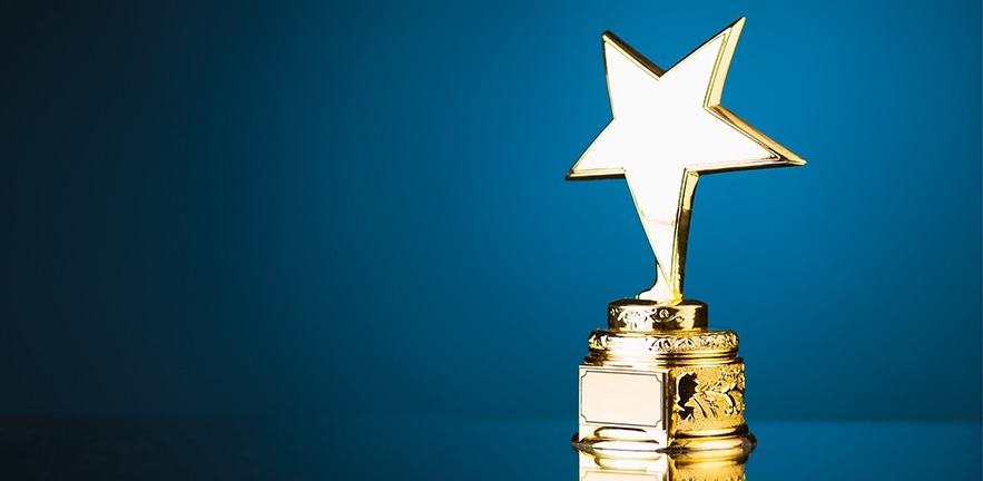 Gold star trophy against blue background.